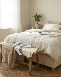 Neatly folded women’s hipster briefs in soft neutral tones on a clean bedroom bench, lit by gentle daylight for a fresh, comfortable retail look.