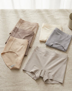 Soft neutral-toned Sloggi-style shorts and briefs neatly arranged on a linen surface in natural daylight, creating a clean and comfortable shopping mood.
